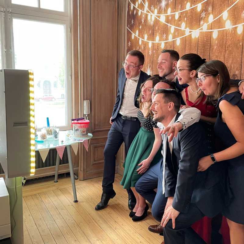 Amis qui se prennent en photo face à un photobooth pendant un mariage