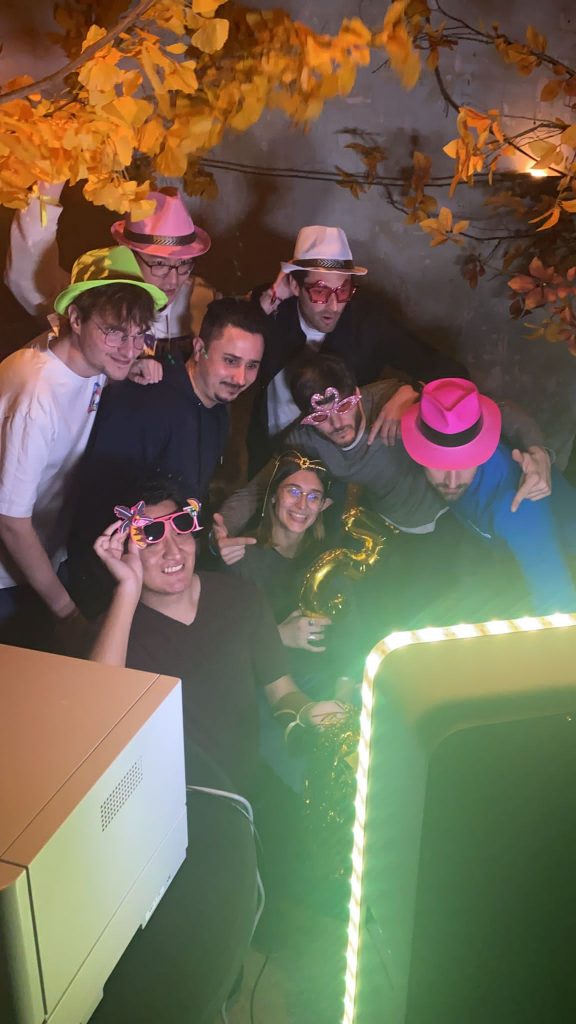 Groupe d'invités posant avec des chapeaux, lunettes et autres accessoires amusants dans le photobooth de la fête d'anniversaire