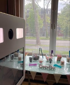 Zone du photobooth décorée avec une variété d'accessoires amusants prêts à être utilisés par les invités de la fête d'anniversaire