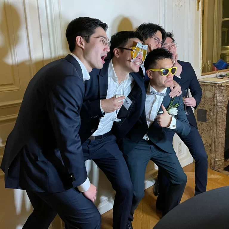 Invités qui prennent la pose devant le photobooth avec des lunettes du pack d’accessoires